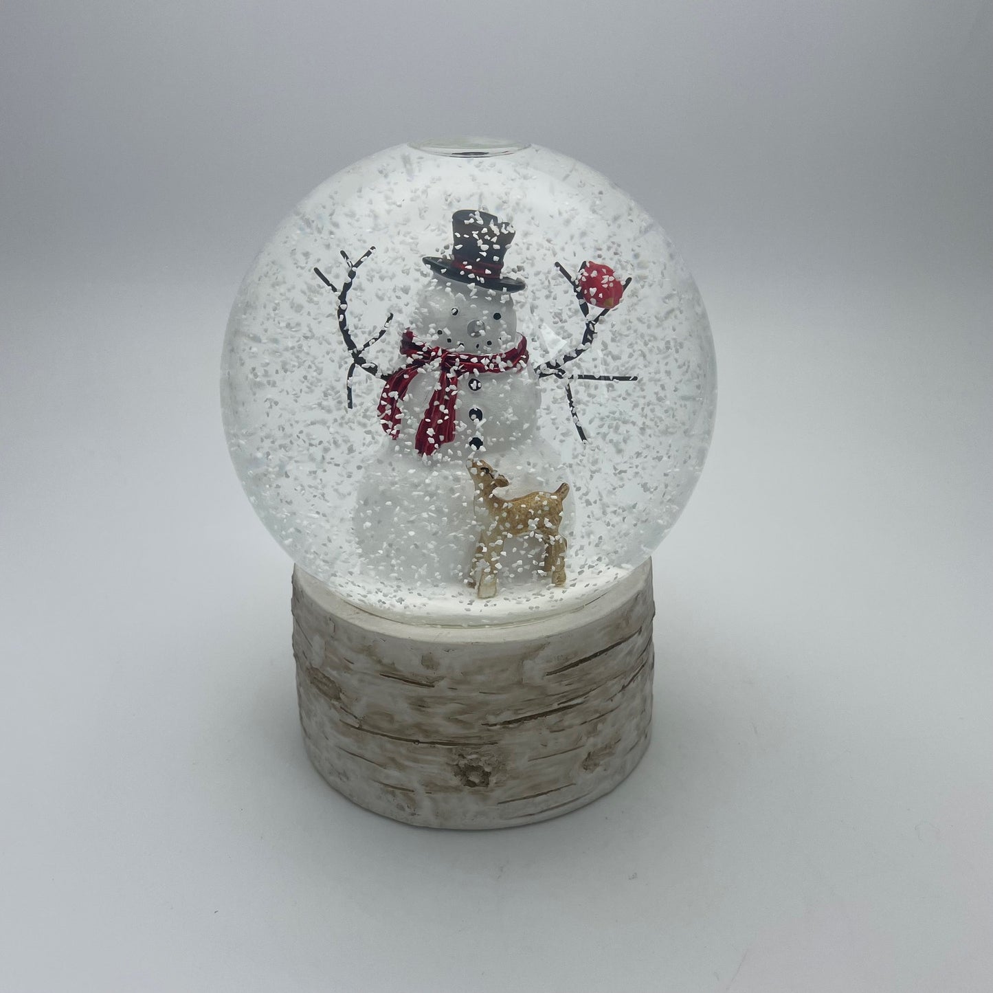 Snow globe with a snowman and reindeer design on a white background