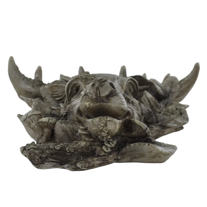 A detailed, rustic gothic figurine shaped like a stag head nestled among mushrooms and textured foliage, finished in a weathered gray-brown stone-like material.