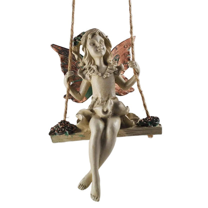 Decorative fairy figurine on a swing against a plain background