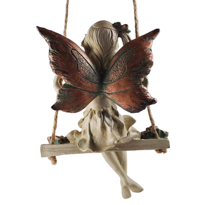 Decorative figurine of a fairy with butterfly wings on a swing against a light background