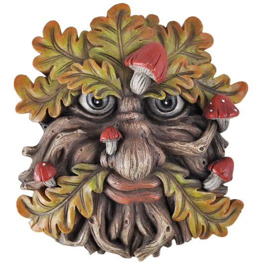 Decorative wall piece resembling a gnomish face with leaves and mushrooms on a white background