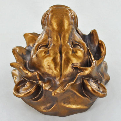 Bronze sculpture of a face on a white background