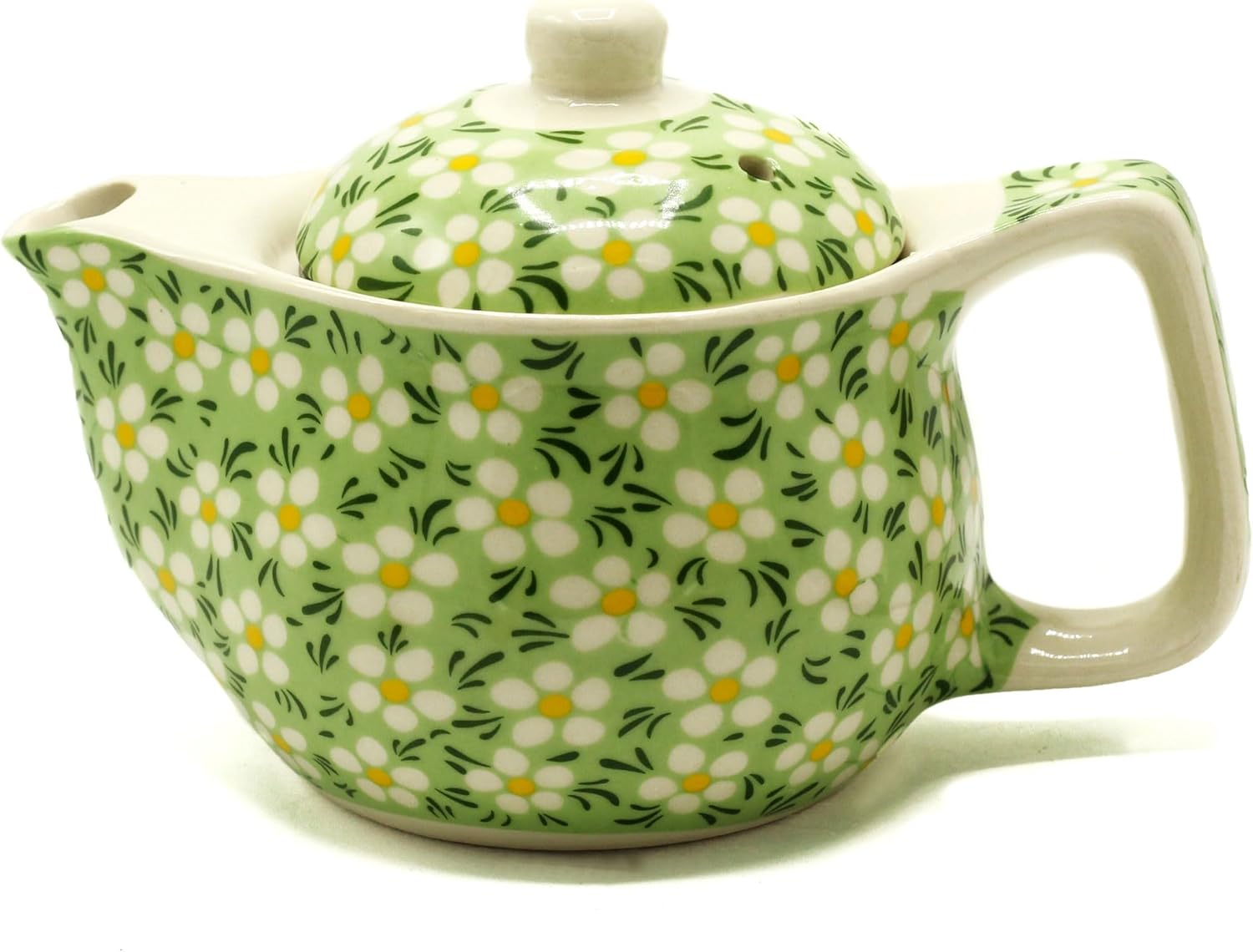 Green ceramic teapot with floral pattern on a white background