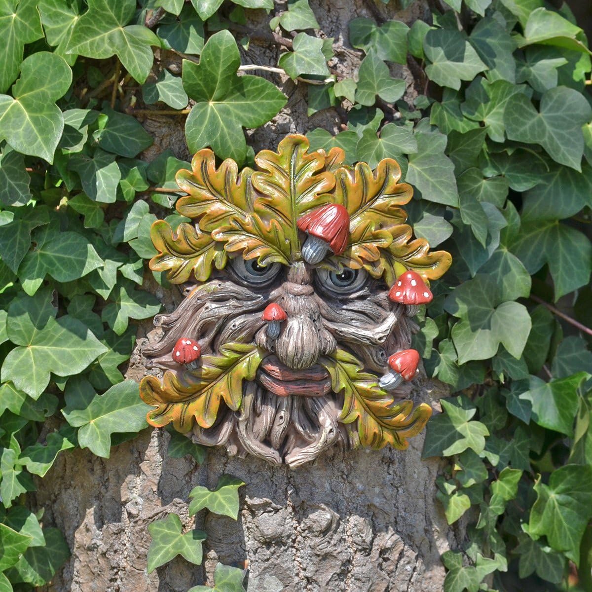 Decorative greenman face on a tree trunk surrounded by ivy