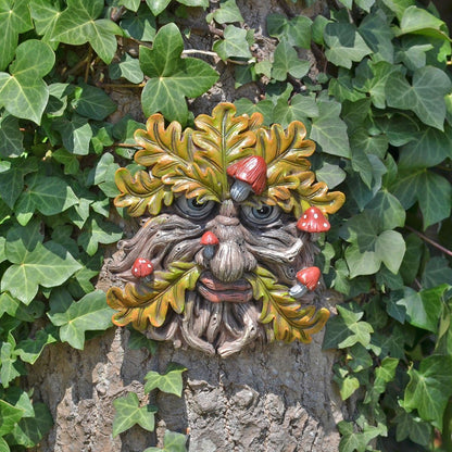 Decorative greenman face on a tree trunk surrounded by ivy