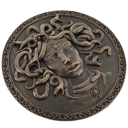 Bronze plaque of Medusa with snakes on a white background