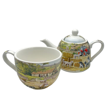 Teapot and mug set with scenic design on a white background