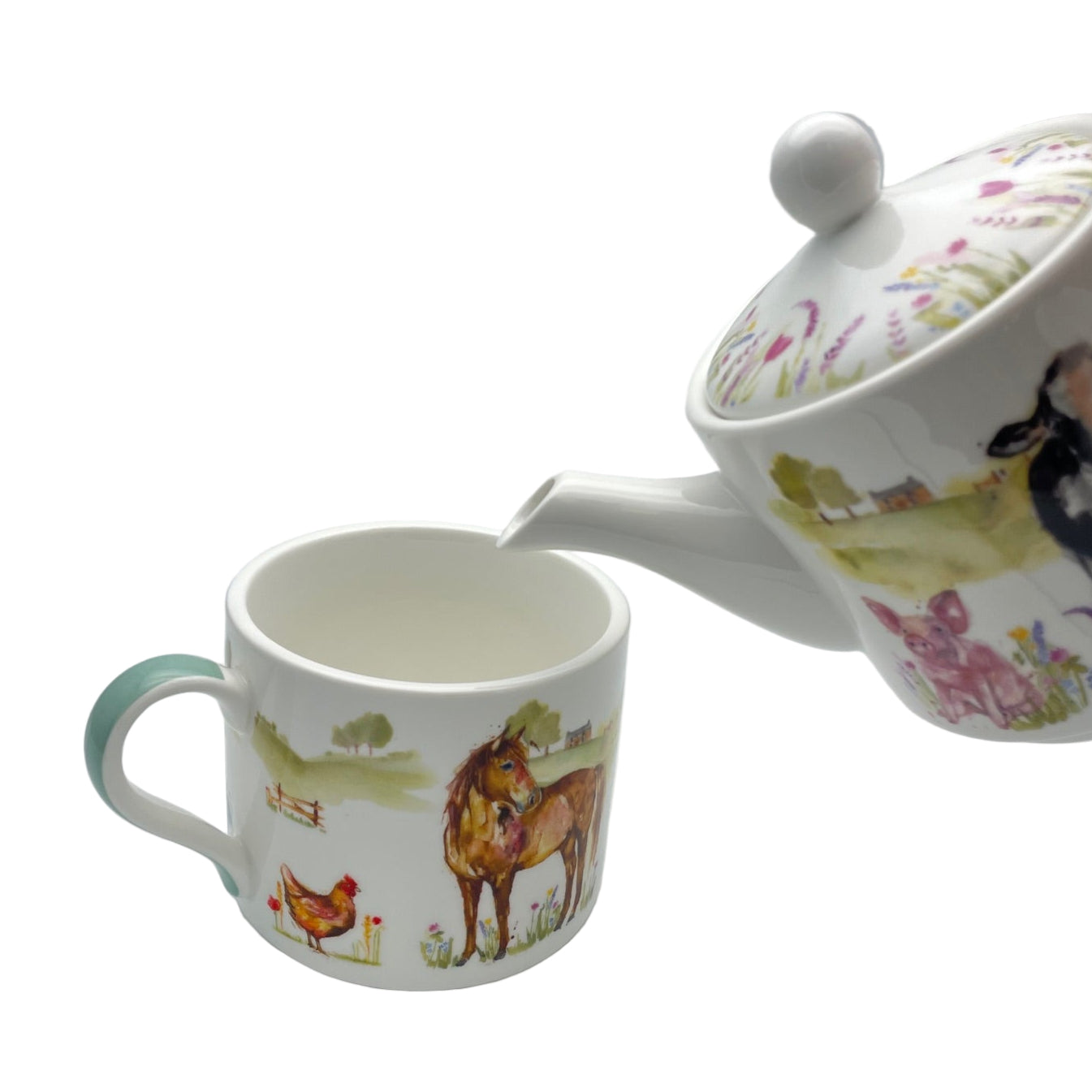 Teapot and mug with farm animal designs on a white background