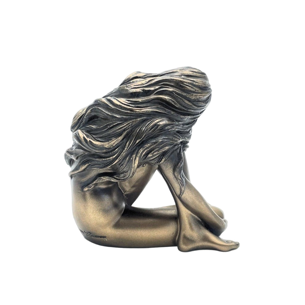 Bronze sculpture of a woman with flowing hair on a white background