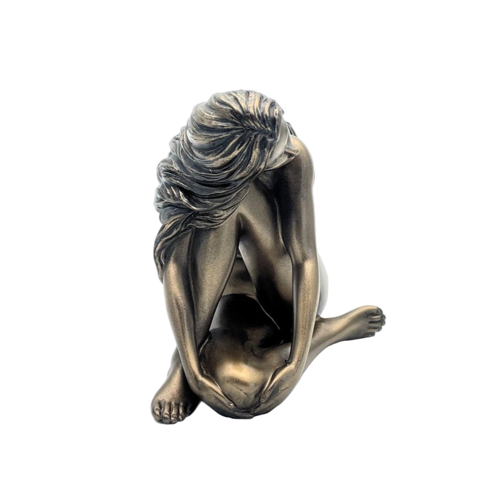 Bronze sculpture of a seated figure with draped hair on a white background