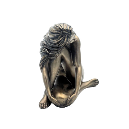 Bronze sculpture of a seated figure with draped hair on a white background