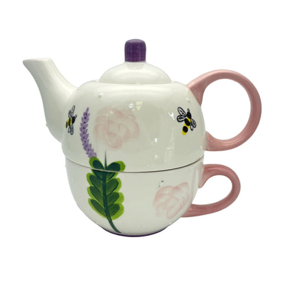 Ceramic teapot with floral and bee design on a white background