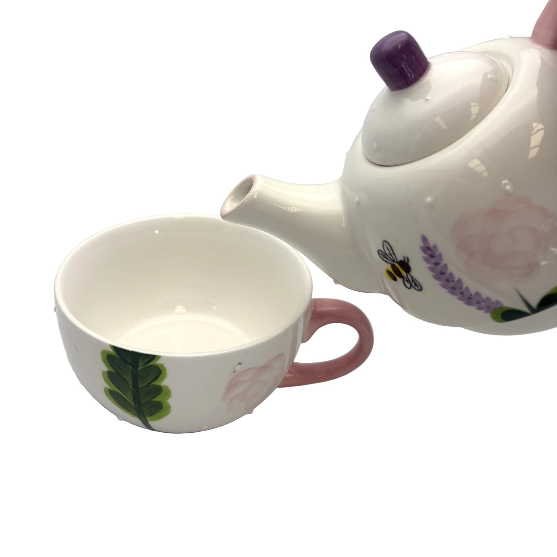 Ceramic teapot and cup with floral designs on a white background