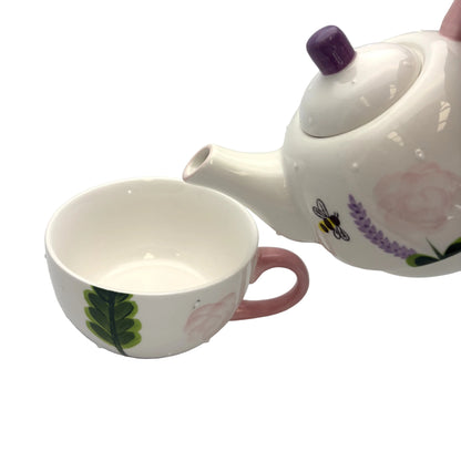 Ceramic teapot and cup with floral designs on a white background