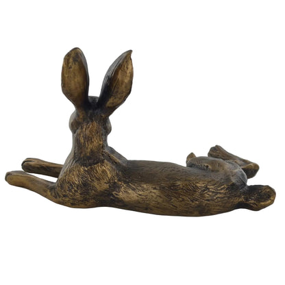 Bronze sculpture of a lying hare on a white background
