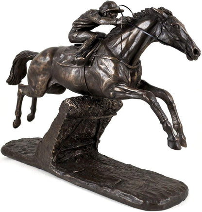 Bronze sculpture of a horse and rider jumping over an obstacle on a white background