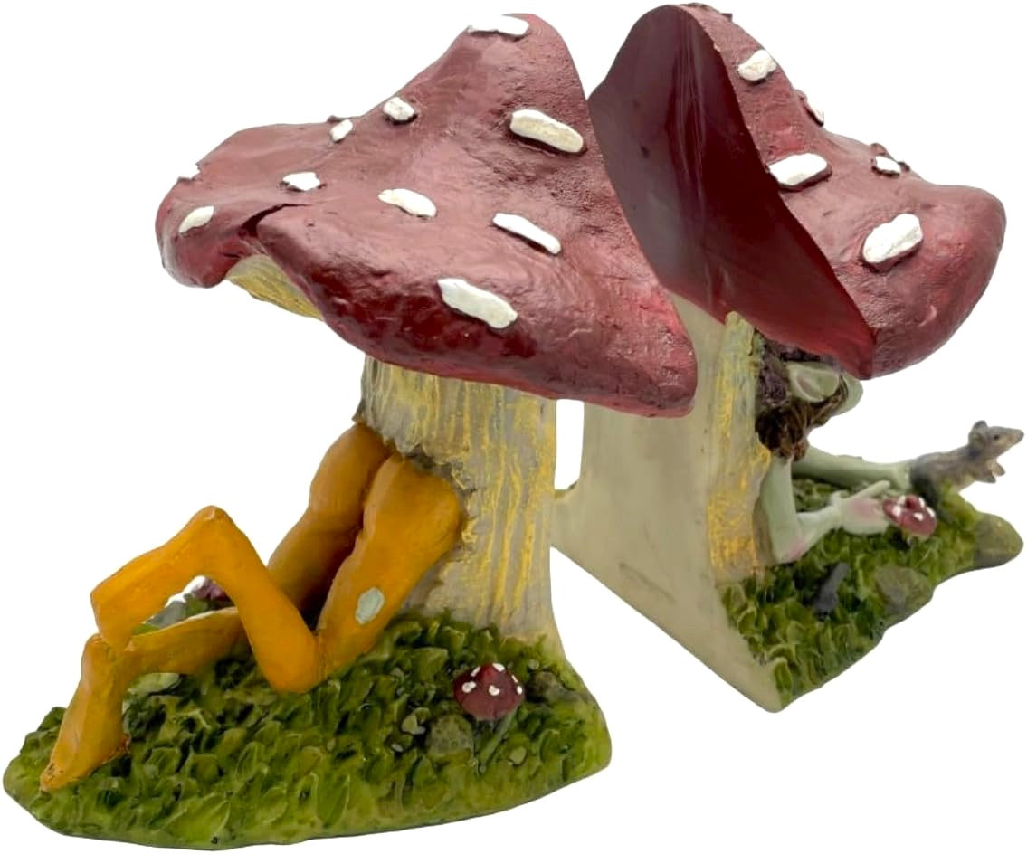 Pixie house made of two large mushrooms with a pixie laying in it, on a white background.