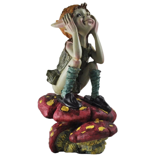 Statue of a pixie sitting on mushrooms with a neutral background
