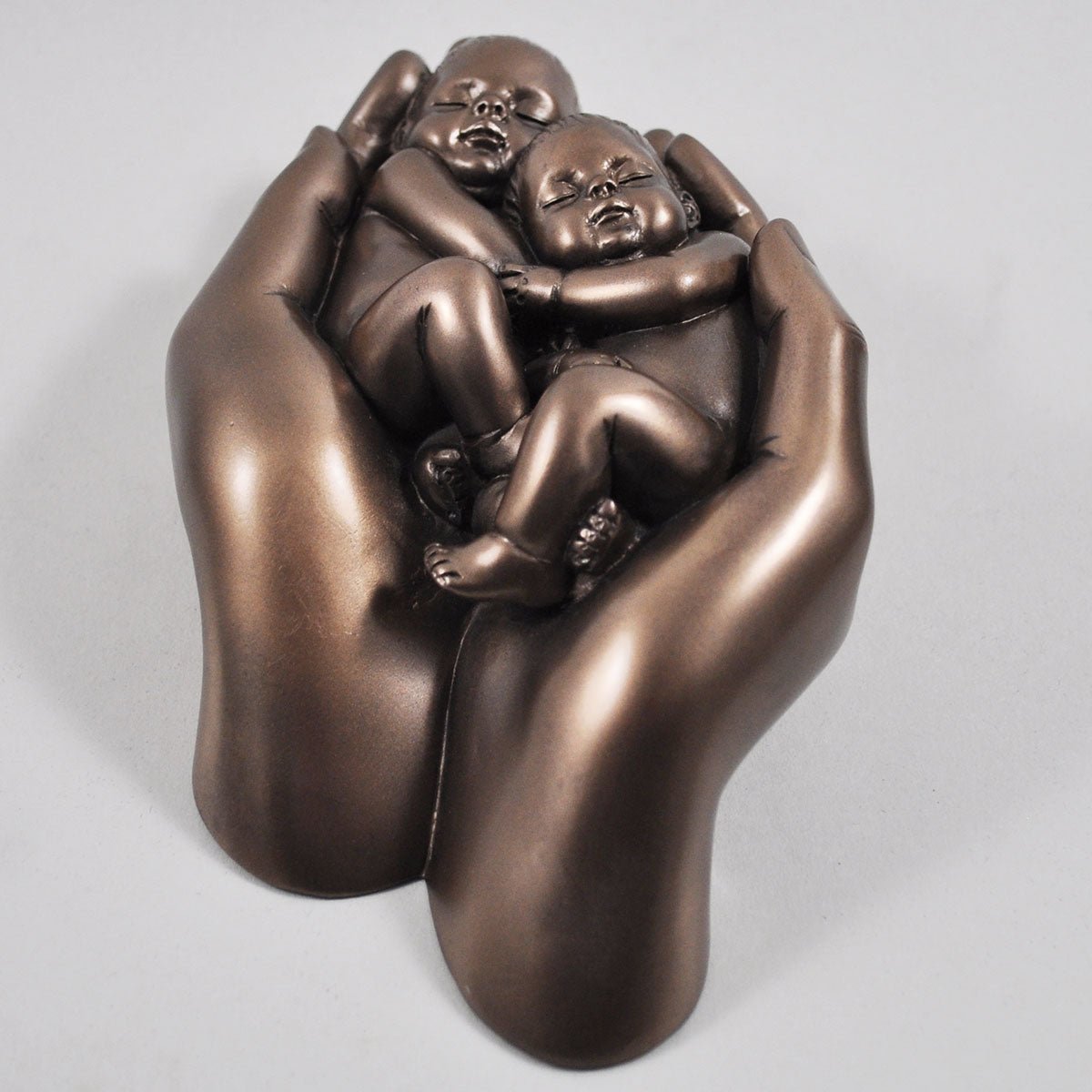 Twin babies in hands In Cold Cast Bronze