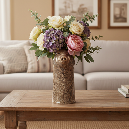 Floral arrangement in a textured wild boar vase on a wooden coffee table in a living room.